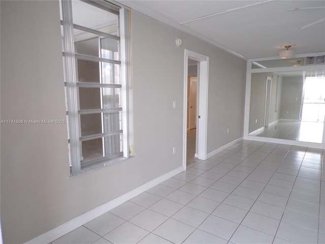 empty room with crown molding and light tile patterned flooring