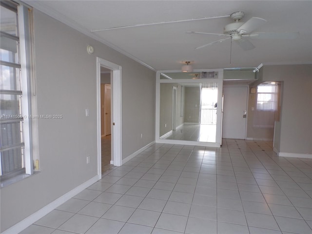 tiled spare room featuring ceiling fan and ornamental molding