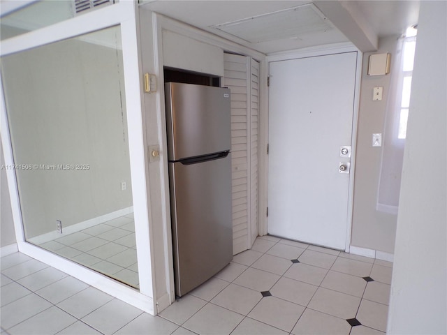 kitchen featuring light tile patterned floors and stainless steel fridge