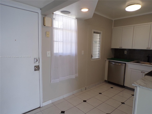 kitchen featuring tasteful backsplash, dishwasher, sink, white cabinets, and light tile patterned floors