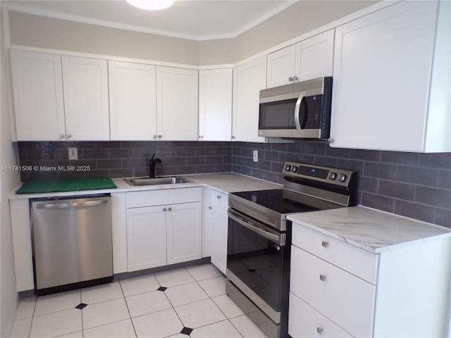 kitchen featuring tasteful backsplash, appliances with stainless steel finishes, sink, and white cabinets