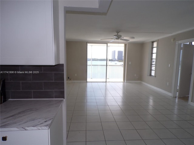 tiled empty room featuring ceiling fan