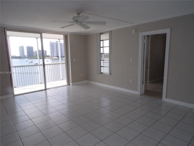 unfurnished room featuring ornamental molding, a water view, light tile patterned floors, and ceiling fan