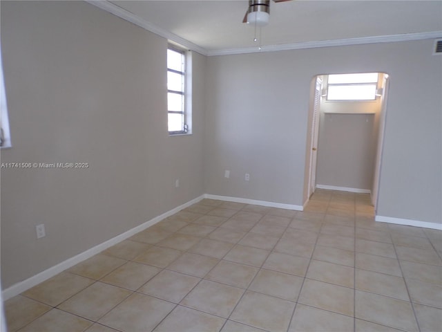 empty room with light tile patterned floors, crown molding, and ceiling fan