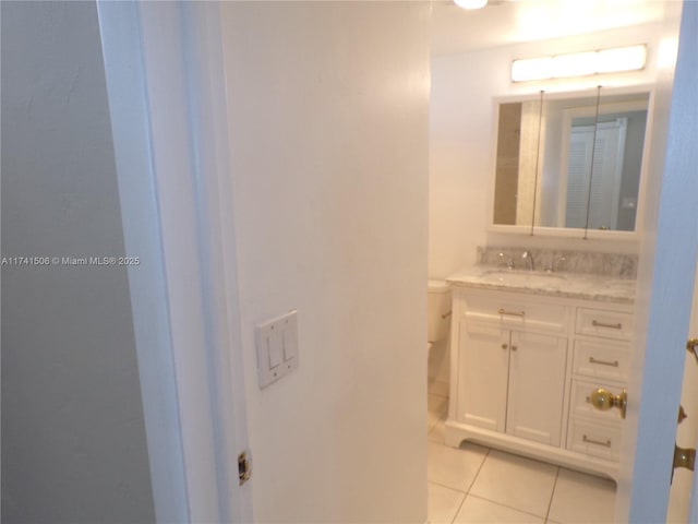 bathroom featuring tile patterned flooring, vanity, and toilet