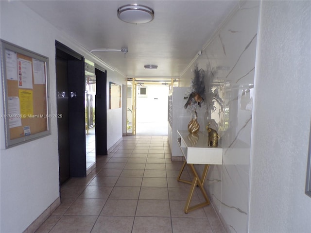 hall with elevator and tile patterned flooring