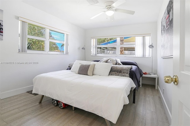 bedroom featuring light wood-type flooring, ceiling fan, and baseboards