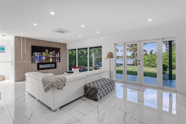 living room featuring a wealth of natural light, marble finish floor, visible vents, and recessed lighting