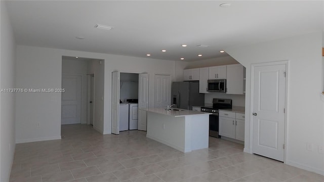 kitchen featuring sink, appliances with stainless steel finishes, a kitchen island with sink, white cabinetry, and washing machine and clothes dryer