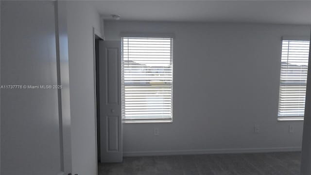 unfurnished room featuring dark colored carpet