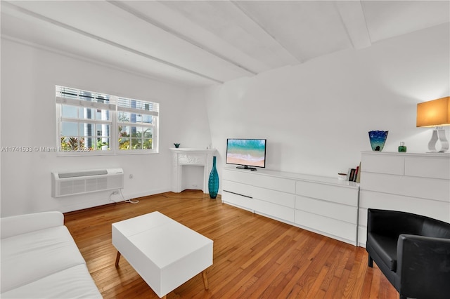 living room with an AC wall unit and hardwood / wood-style floors