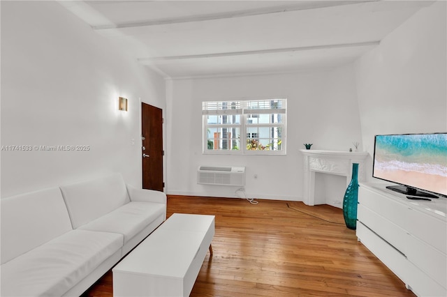 living room with light hardwood / wood-style flooring, beamed ceiling, and a wall mounted AC