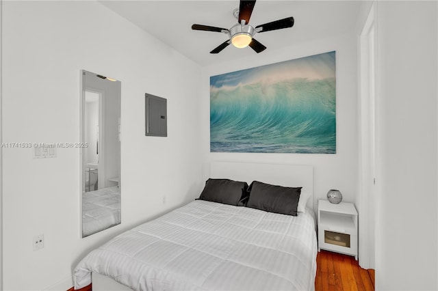 bedroom featuring ceiling fan, wood-type flooring, and electric panel