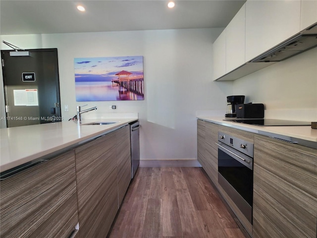 kitchen featuring white cabinetry, sink, hardwood / wood-style flooring, and appliances with stainless steel finishes