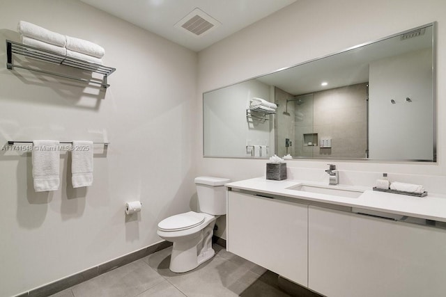 bathroom featuring tile patterned flooring, vanity, a shower with shower door, and toilet