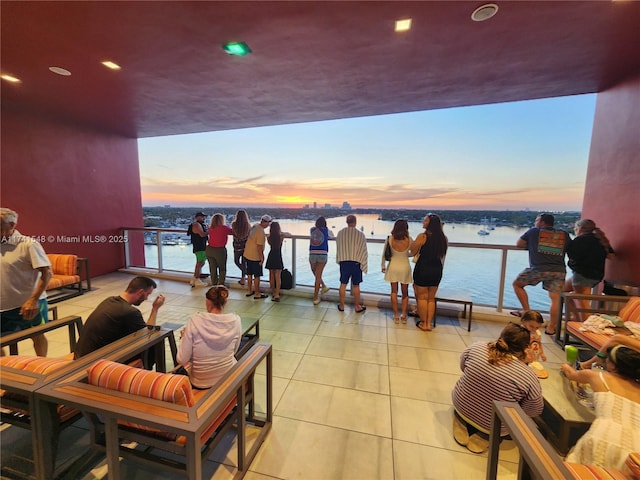 patio terrace at dusk with a balcony and a water view