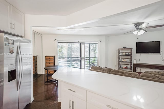 kitchen with ceiling fan, dark wood-style flooring, white cabinets, open floor plan, and stainless steel fridge with ice dispenser