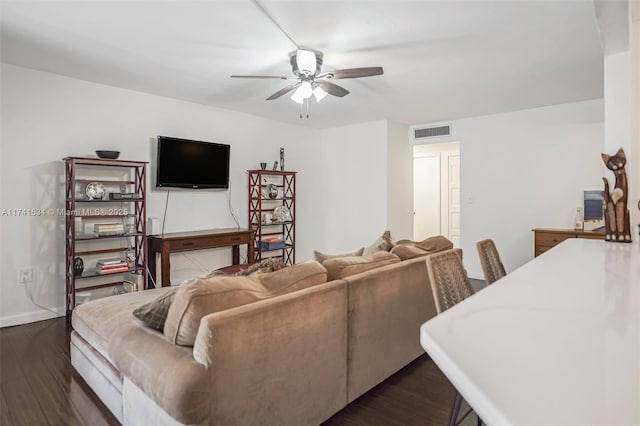 living area featuring dark wood-style floors, ceiling fan, visible vents, and baseboards