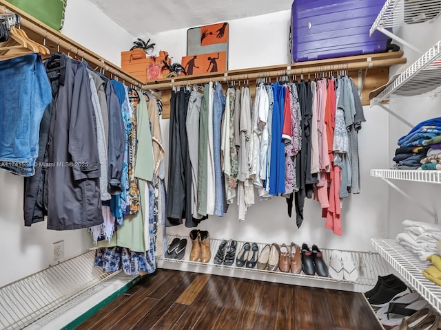 walk in closet with wood finished floors