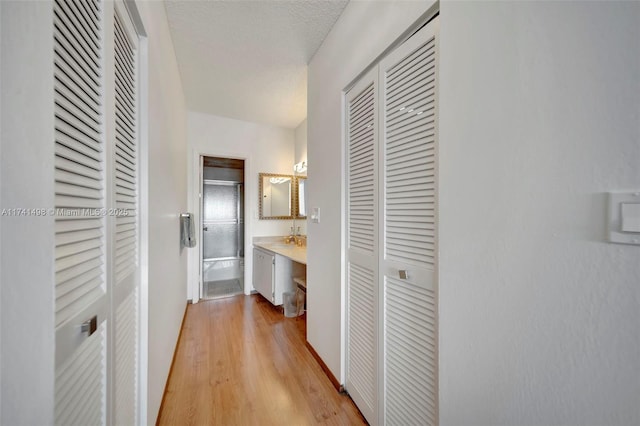 1985 S Ocean Dr Unit 22G, Hallandale Beach, FL 33009 - hallway featuring a textured ceiling and light wood-type flooring