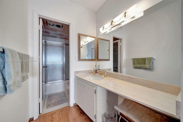 1985 S Ocean Dr Unit 22G, Hallandale Beach, FL 33009 - full bathroom featuring vanity, wood-type flooring, enclosed tub / shower combo, and toilet