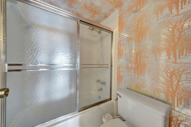 1985 S Ocean Dr Unit 22G, Hallandale Beach, FL 33009 - bathroom featuring toilet and bath / shower combo with glass door
