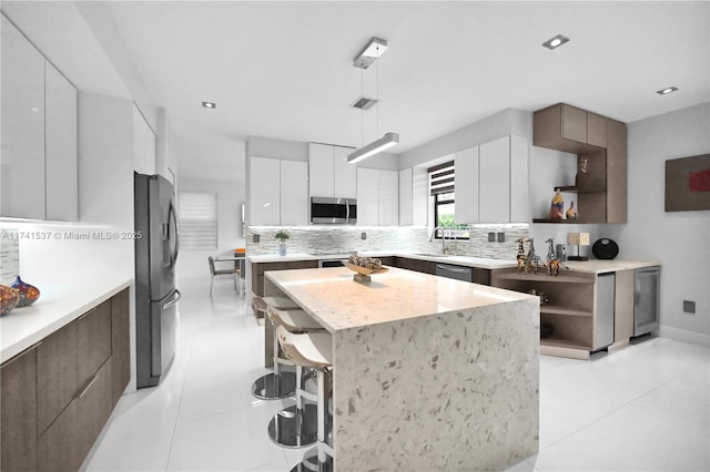 kitchen featuring white cabinetry, stainless steel appliances, a kitchen island, and backsplash