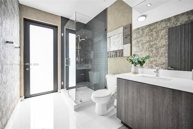 bathroom with a shower with door, vanity, tile patterned flooring, and toilet