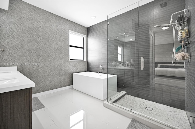 bathroom featuring vanity, plus walk in shower, and tile patterned flooring