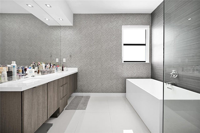 bathroom featuring vanity, tile patterned floors, and a tub to relax in