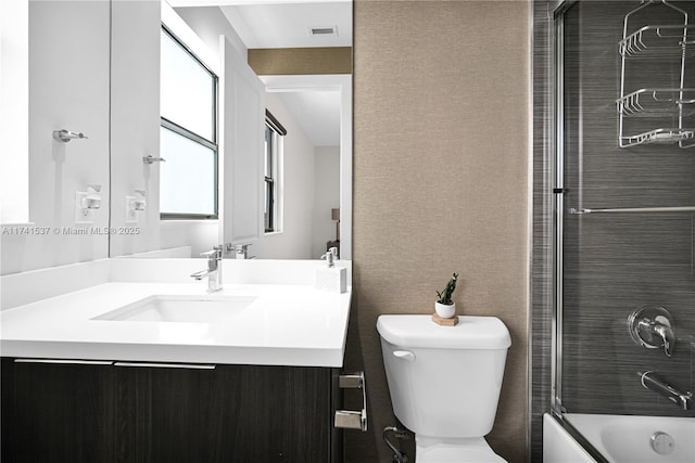 full bathroom featuring bath / shower combo with glass door, vanity, and toilet