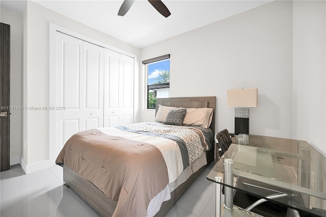 tiled bedroom featuring ceiling fan and a closet