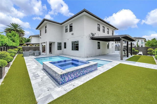 back of property with a pool with hot tub, a yard, and a patio