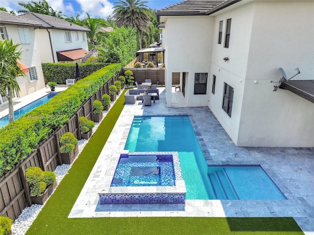 view of swimming pool with an in ground hot tub, outdoor lounge area, and a patio area