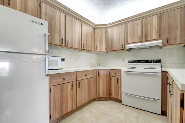 kitchen with sink, light tile patterned floors, white appliances, and decorative backsplash