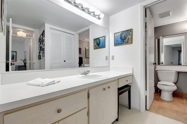 bathroom featuring tile patterned flooring, vanity, and toilet