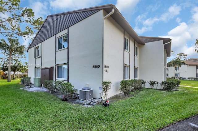 view of home's exterior featuring a lawn and central air condition unit