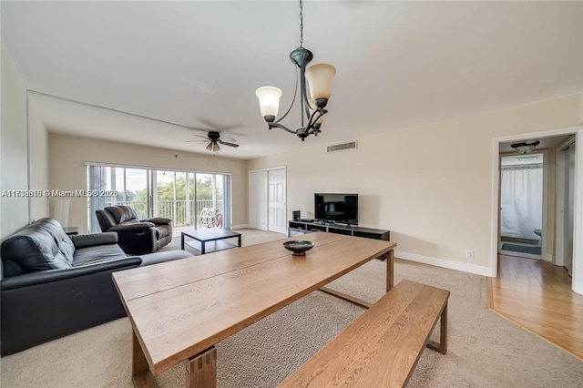 living room featuring ceiling fan with notable chandelier