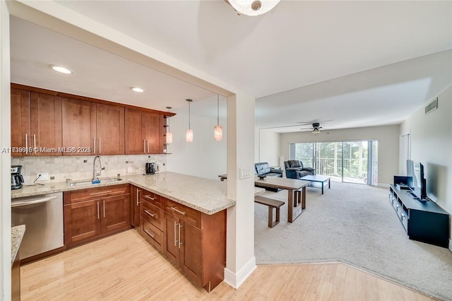 kitchen with sink, hanging light fixtures, light carpet, stainless steel dishwasher, and kitchen peninsula