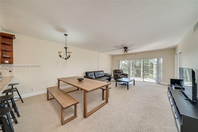 carpeted living room with ceiling fan with notable chandelier