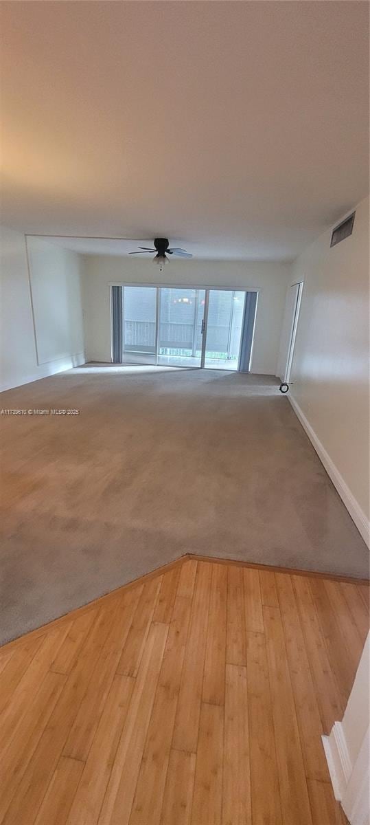 spare room with ceiling fan and light wood-type flooring