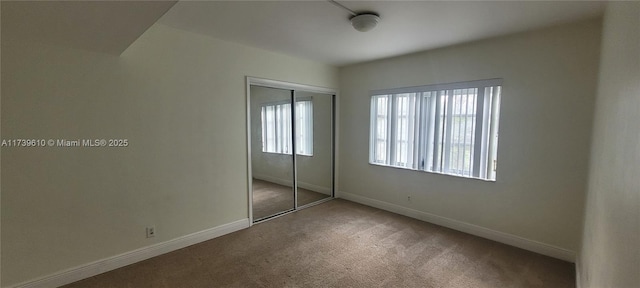 unfurnished bedroom with carpet flooring and a closet