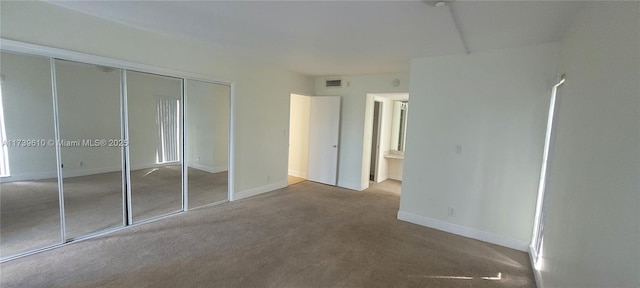 unfurnished bedroom featuring carpet floors and a closet