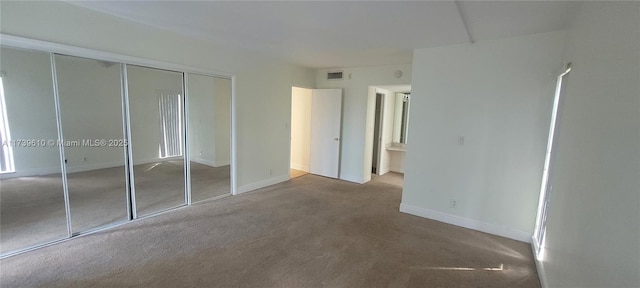 unfurnished bedroom with carpet floors and a closet