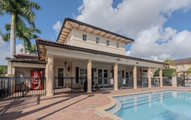 back of house with a patio and a community pool