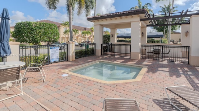 view of pool with a hot tub and a patio