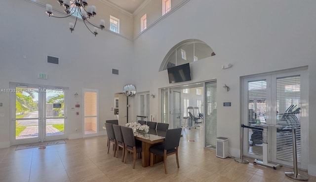 dining area with an inviting chandelier, crown molding, french doors, and a healthy amount of sunlight