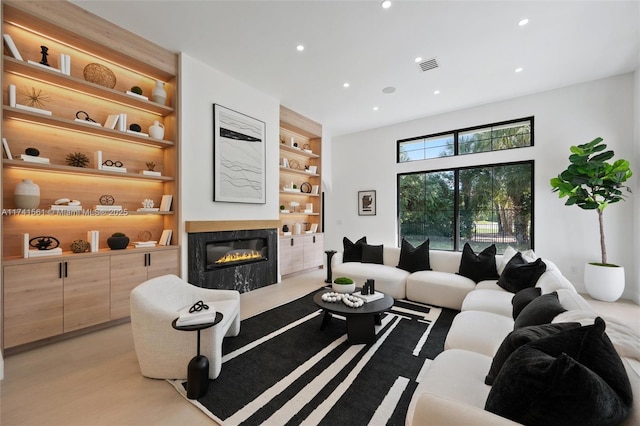 living room with built in features and a fireplace