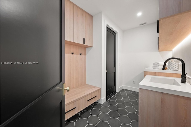 mudroom featuring sink and dark tile patterned flooring