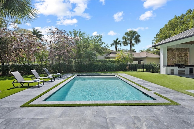 view of pool with area for grilling, grilling area, a lawn, and a patio